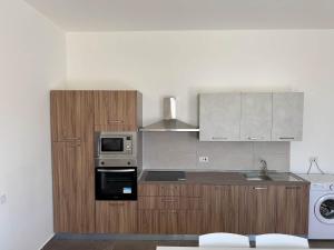 a kitchen with wooden cabinets and a microwave at Cozy 1-Bedroom Penthouse - by HostMT in Taʼ Penza