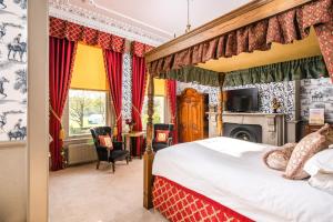a bedroom with a canopy bed and a fireplace at The Ayrlington Guesthouse in Bath
