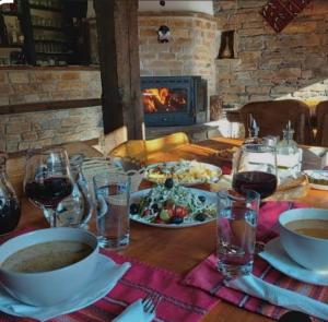 a table with food and wine glasses and a fireplace at The Waterfall - Free Parking in Balchik