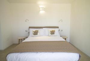 a bedroom with a large bed with two tables at Borgo Bianco affittacamere in Budoni
