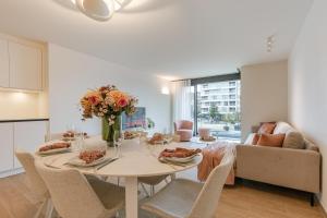 a dining room with a table with a vase of flowers at La Mirage 02 in De Panne