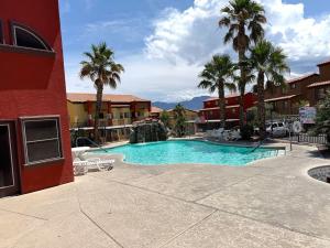 a swimming pool with palm trees in a hotel at Bright and Spacious 2 Story Condo in Mesquite