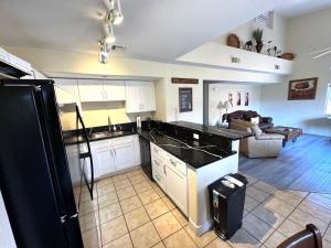 a kitchen with a black refrigerator and a living room at Bright and Spacious 2 Story Condo in Mesquite