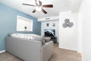 a living room with a couch and a ceiling fan at Cozy Millcreek Home SLC in Millcreek