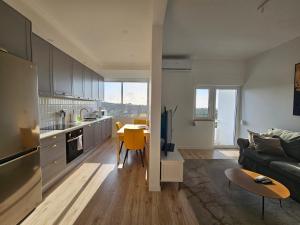 Una cocina y una sala de estar con un sofá y una mesa. en Arrabida Sunset Valley, en Palmela