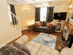 a living room with a couch and a tv at Corner Cottage in Carnforth
