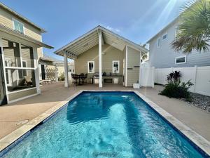 una piscina frente a una casa en Birdies and Bos Beach Bungalow, en Port Aransas