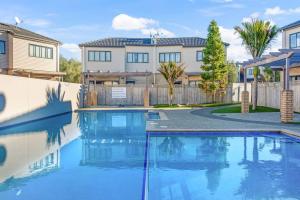 a swimming pool in front of a house at Sweet Sunshine Nest with Pool, Aircon and Parking in Auckland