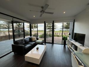 a living room with a black couch and a tv at Esperance Waterfront Apartment in Esperance
