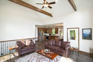 a living room with two chairs and a ceiling fan at Smokeys Summit Epic View Hot Tub Fireplace in Sevierville