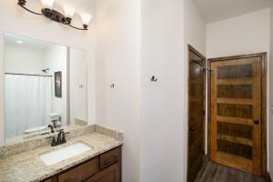 a bathroom with a sink and a mirror at Smokeys Summit Epic View Hot Tub Fireplace in Sevierville +47 photos