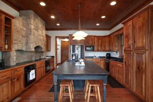 ダンドリッジにあるBlessed Getaway Theater LakeView GAMESの木製のキャビネットとスツール付きのテーブルを備えた広いキッチン