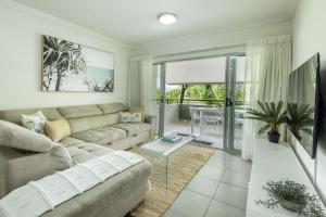 克瓦拉海滩Kewarra Beach Coastal Retreat 2BR Apt with Pool and BBQ的带沙发和桌子的客厅