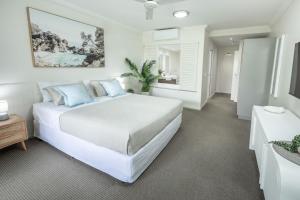 克瓦拉海滩Kewarra Beach Coastal Retreat 2BR Apt with Pool and BBQ的一间带大床和窗户的白色卧室