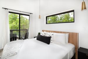 a bedroom with a white bed and a window at The Little Timber Cozy Hot Tub Fireplace in Townsend
