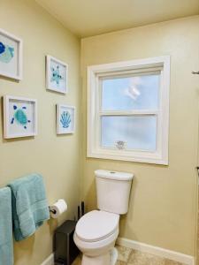 a bathroom with a toilet and a window at Old Tacoma Victorian Charm with water views in Tacoma