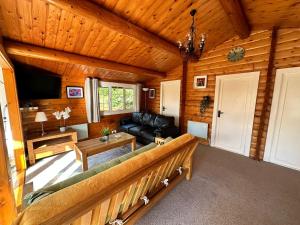 a living room with a couch and a tv at Caban Enfys in Trawsfynydd