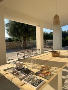 Una mesa de madera con libros y platos encima. en Ziran Resort, en Noto