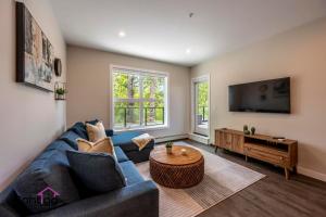 a living room with a blue couch and a table at Decked Out, Mtn Views, AC, Big Patio, DT, BBQ in Golden
