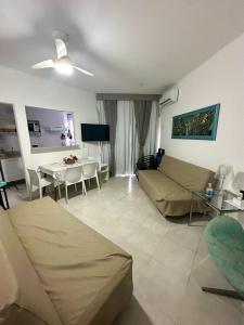 a living room with a couch and a table at Apartamento Reserva do Sahy - Condomínio Aldeia dos Reis in Mangaratiba +19 photos