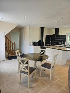 a kitchen with a glass table and two chairs at Gîte le bûcher du château in Barbeville +23 photos