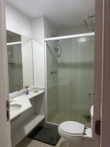 a bathroom with a shower and a toilet and a sink at Apartamento Reserva do Sahy - Condomínio Aldeia dos Reis in Mangaratiba