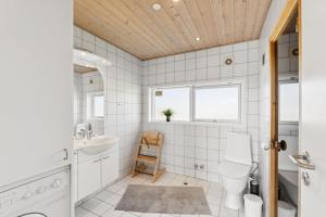 a bathroom with a toilet and a sink at Feriehus 1127 in Ringkøbing +28 photos