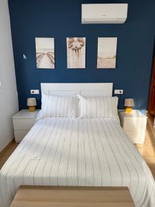a bedroom with a large white bed with blue walls at Break Room in Playa Honda