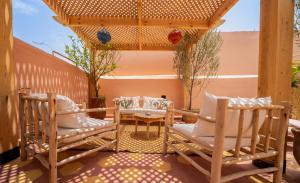 eine Terrasse mit 2 Stühlen und einem Tisch auf der Terrasse in der Unterkunft Riad Le Soleil de Bahia in Marrakesch