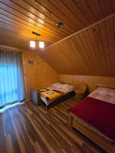 een kamer met twee bedden in een houten hut bij domek monika in Okuninka