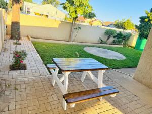 a picnic table and a bench in a backyard at LOR Homes in Gaborone