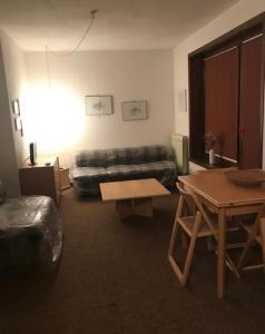 a living room with a couch and a table at Ampio Monolocale Lizzola con box in Lizzola Alta +1 photo
