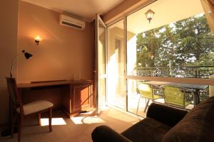 een woonkamer met een bank en een groot raam bij Първа линия Апартаменти in Pomorie