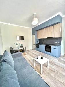 a living room with a blue couch and a table at С новым ремонтом Expo new life 2 in Taldykolʼ
