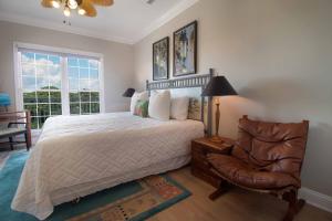 a bedroom with a bed and a chair at Oceanfront Garden in Folly Beach