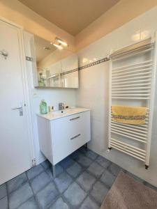a white bathroom with a sink and a mirror at Gîte de France Marinette 3 épis - Gîte de France 4 personnes MAE-0003 in Jouix