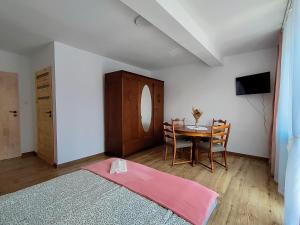 a bedroom with a table and a dining room at Jaśmin -pokoje gościnne in Ustka