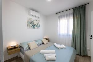 a bedroom with a blue bed with towels on it at Villa Bijaći in Kastel Novi +95 photos