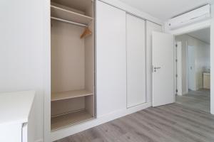 an empty closet with white cabinets and a door at A Casa Choupal in Azeitao +29 photos