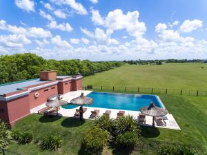 an aerial view of a house with a swimming pool and a field at Puesto Viejo in Cañuelas
