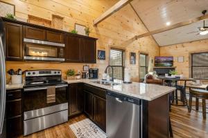 a kitchen with wooden cabinets and a stove top oven at New Build Hot Tub Fireplace in Pigeon Forge