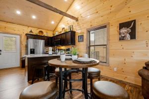 a kitchen with a table and chairs in a cabin at New Build Hot Tub Fireplace in Pigeon Forge +40 photos