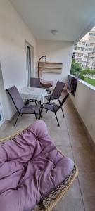 a room with a table and chairs on a balcony at Apartman Cristo Becici in Rafailovici