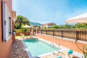 une piscine sur le côté d'une maison dans l'établissement Villa Mandola by Villa Plus, à Acharavi