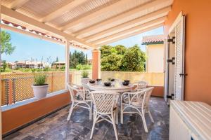 un patio avec une table et des chaises sur un balcon dans l'établissement Villa Mandola by Villa Plus, à Acharavi