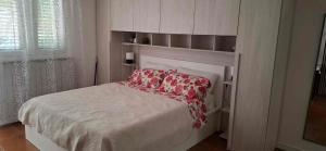 a bedroom with a white bed with a red pillow at Mike1890 in Portorož