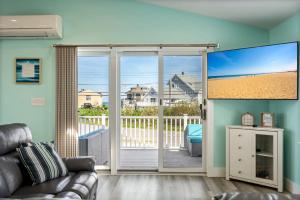 a living room with a sliding glass door to a balcony at 2-Min Walk to Beach Large Deck with Outdoor Sofas in Wells +35 photos