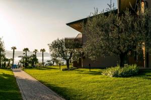 a house with a grassy yard next to a building at Apartment in Manerba del Garda 22048 in Raffa
