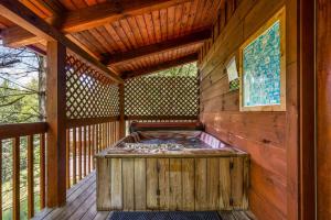 a wooden cabin with a hot tub on a deck at Location Private Log Cabin Hot Tub Fireplace in Pigeon Forge