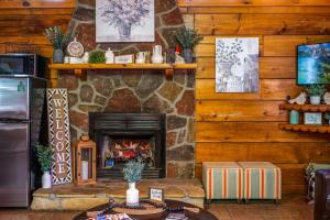 a stone fireplace in a living room with a table at Location Private Log Cabin Hot Tub Fireplace in Pigeon Forge